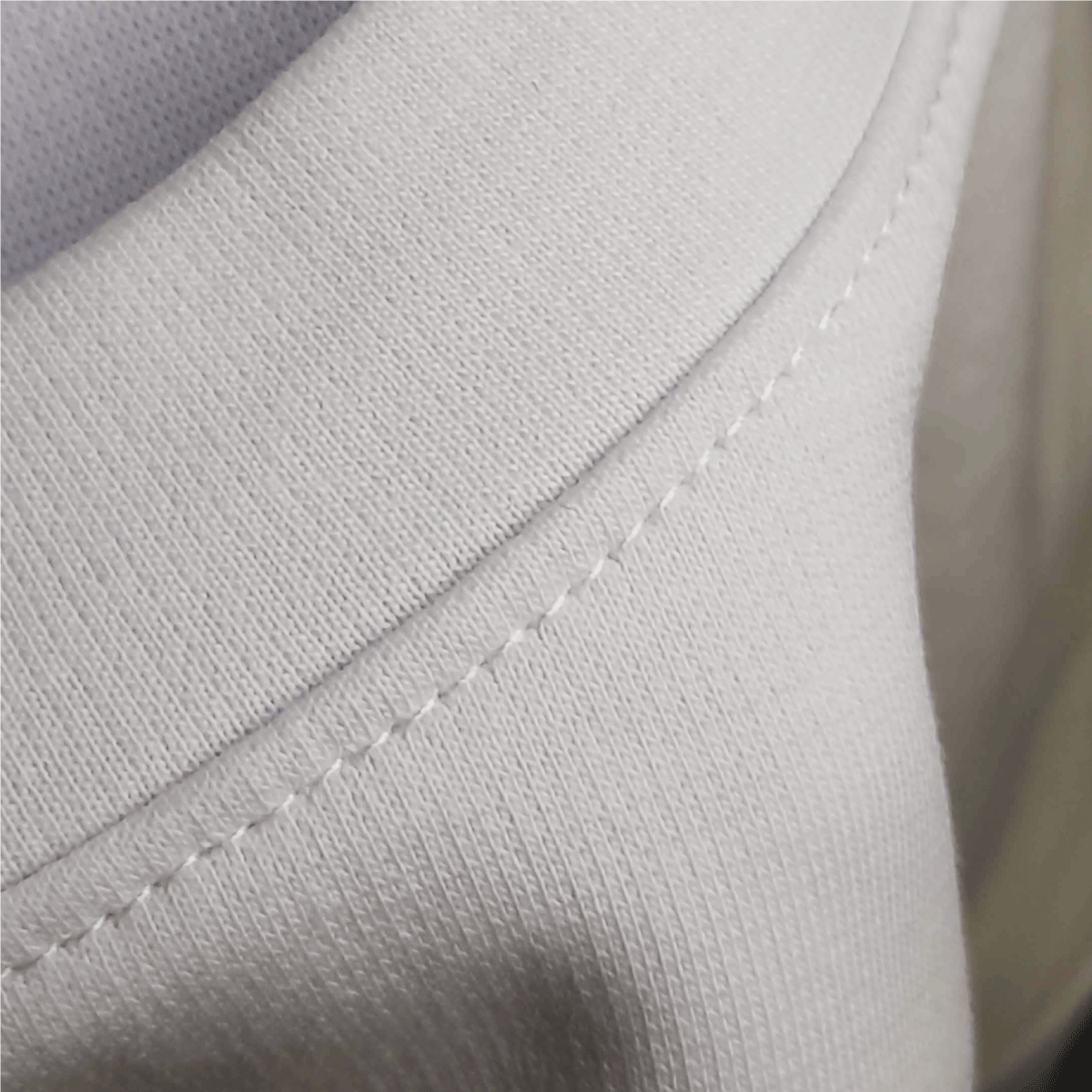 Detalle de costura y cuello en rib de camiseta blanca oversized GuaHapen