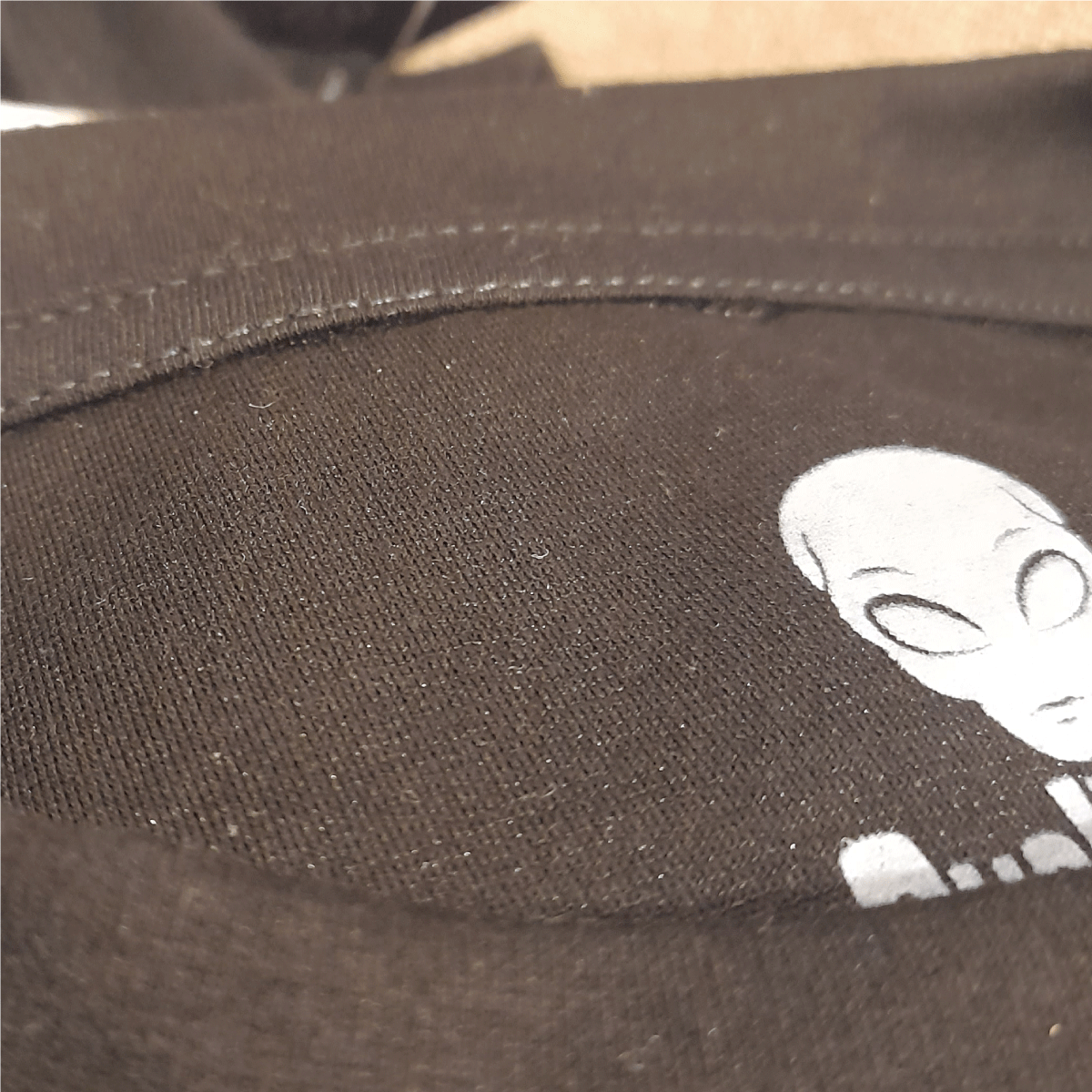 Camiseta oversized negra con diseño de alien cacería neón.